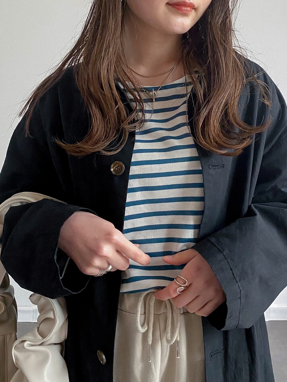 グリーン系のTシャツ/カットソー、ベージュ系のその他パンツ、ホワイト系のショルダーバッグを着用したレディースの春コーディネートの2枚目の写真