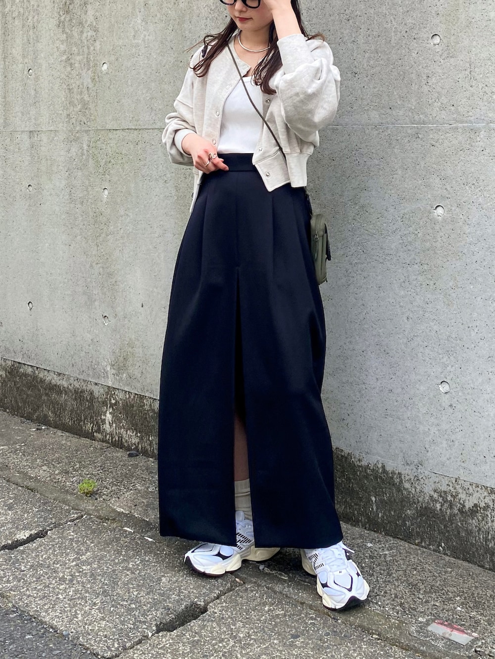 ベージュ系のスウェット、ホワイト系のタンクトップ、ブラック系のスカートを着用したレディースの春コーディネートの3枚目の写真