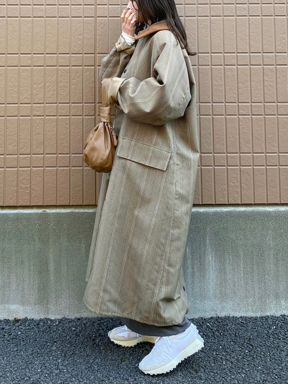 グリーン系のニット/セーター、ベージュ系のその他アウター、ベージュ系のワンピースを着用したレディースの冬コーディネートの2枚目の写真