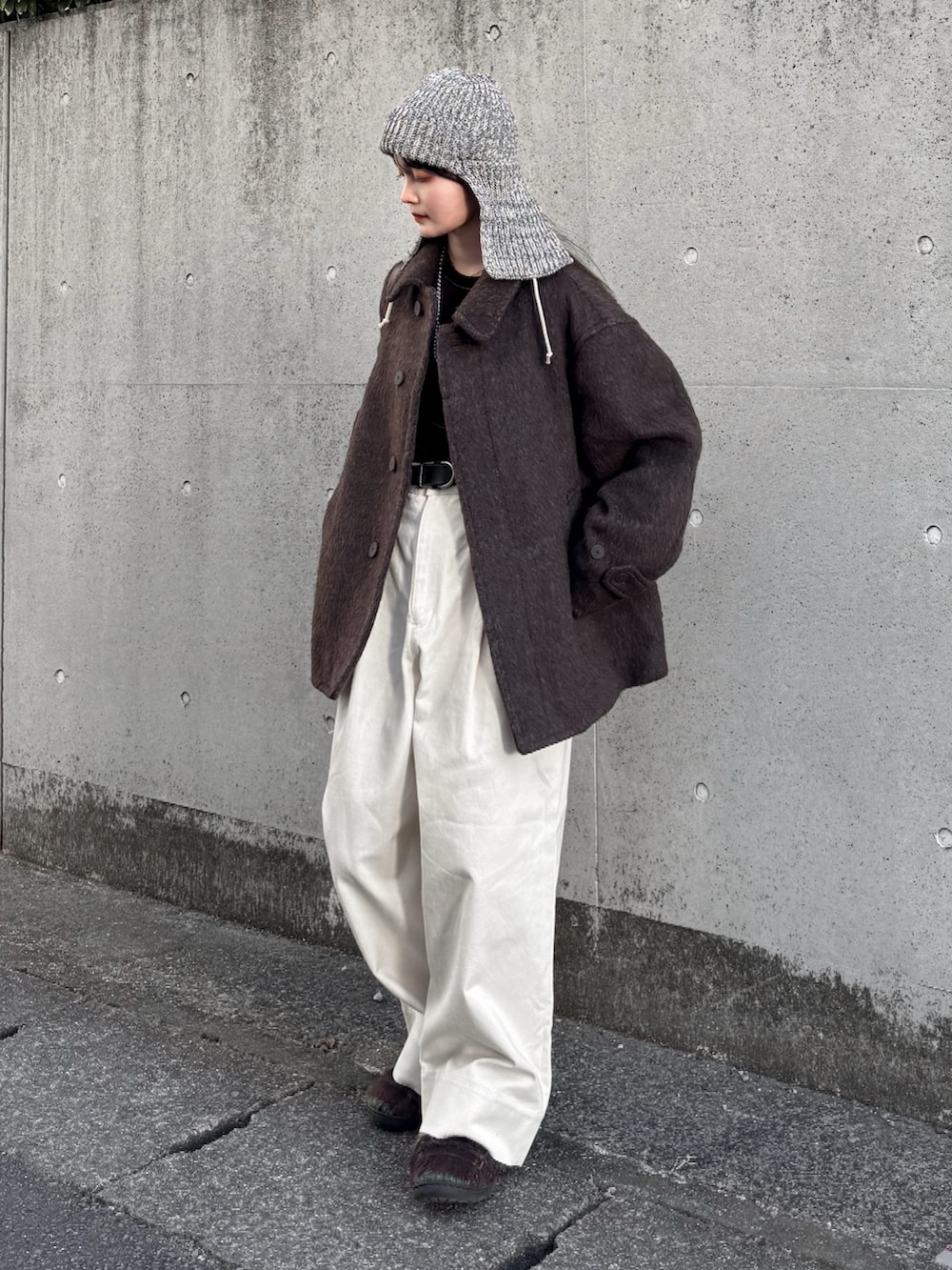 ブラウン系のブルゾン、ブラウン系のTシャツ/カットソー、ホワイト系のその他パンツを着用したレディースの冬コーディネートの2枚目の写真