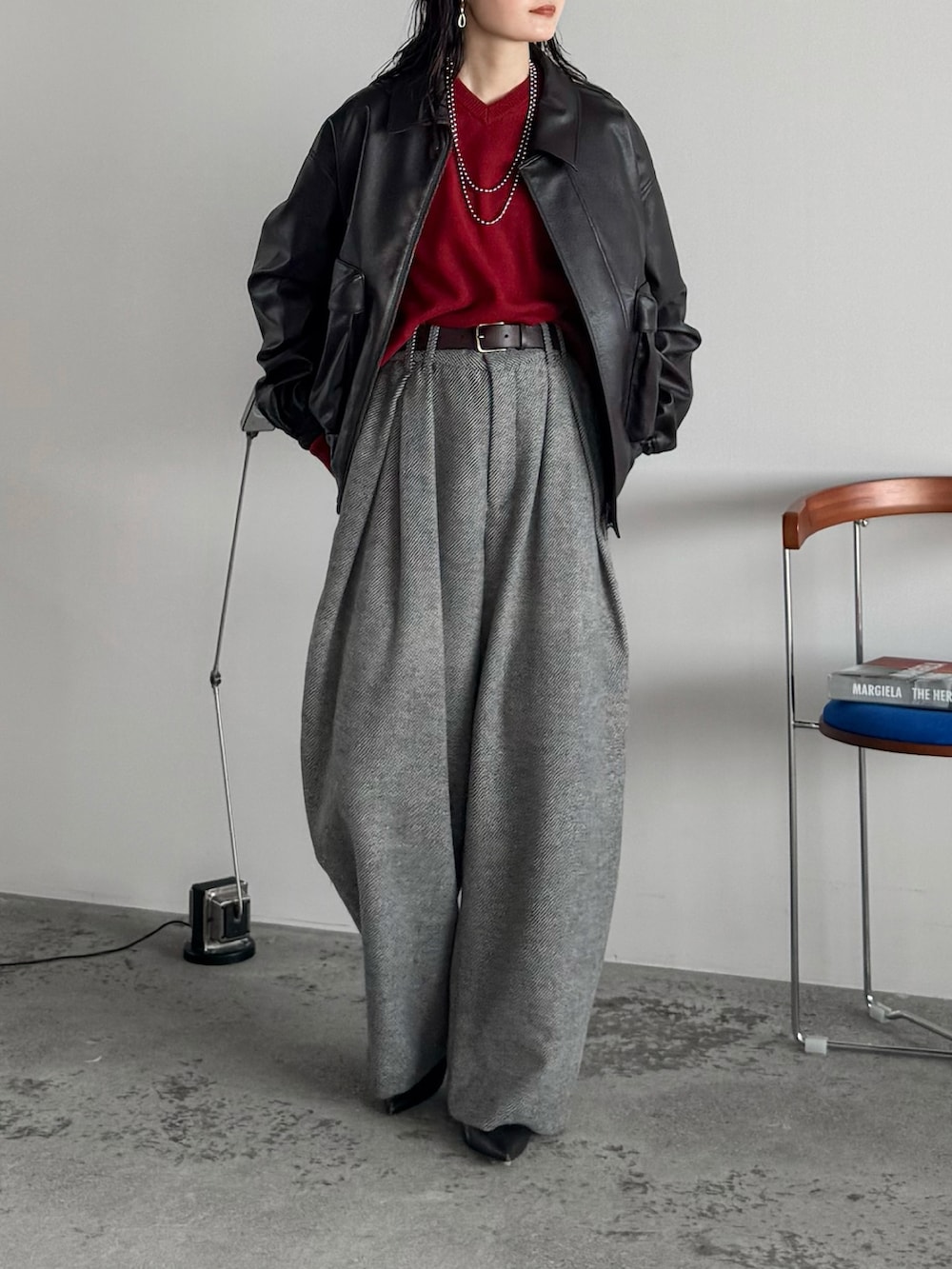 ブラウン系のブルゾン、レッド系のニット/セーター、グレー系のスラックスを着用したレディースの冬コーディネートの2枚目の写真