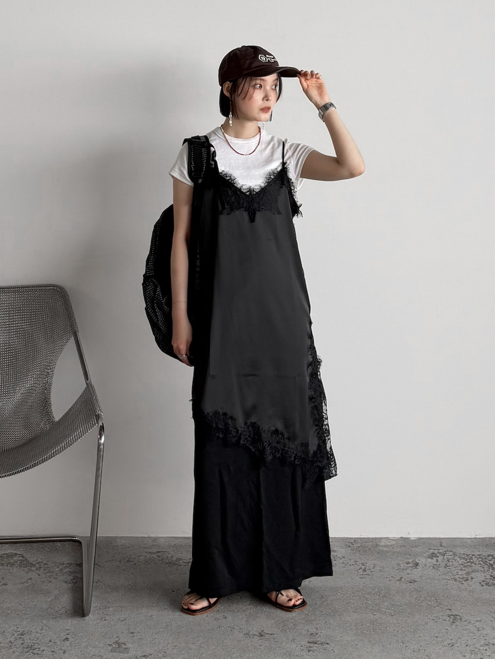 ブラック系のキャミソール、ブラック系のバックパック/リュック、ホワイト系のTシャツ/カットソーを着用したレディースの夏コーディネートの2枚目の写真