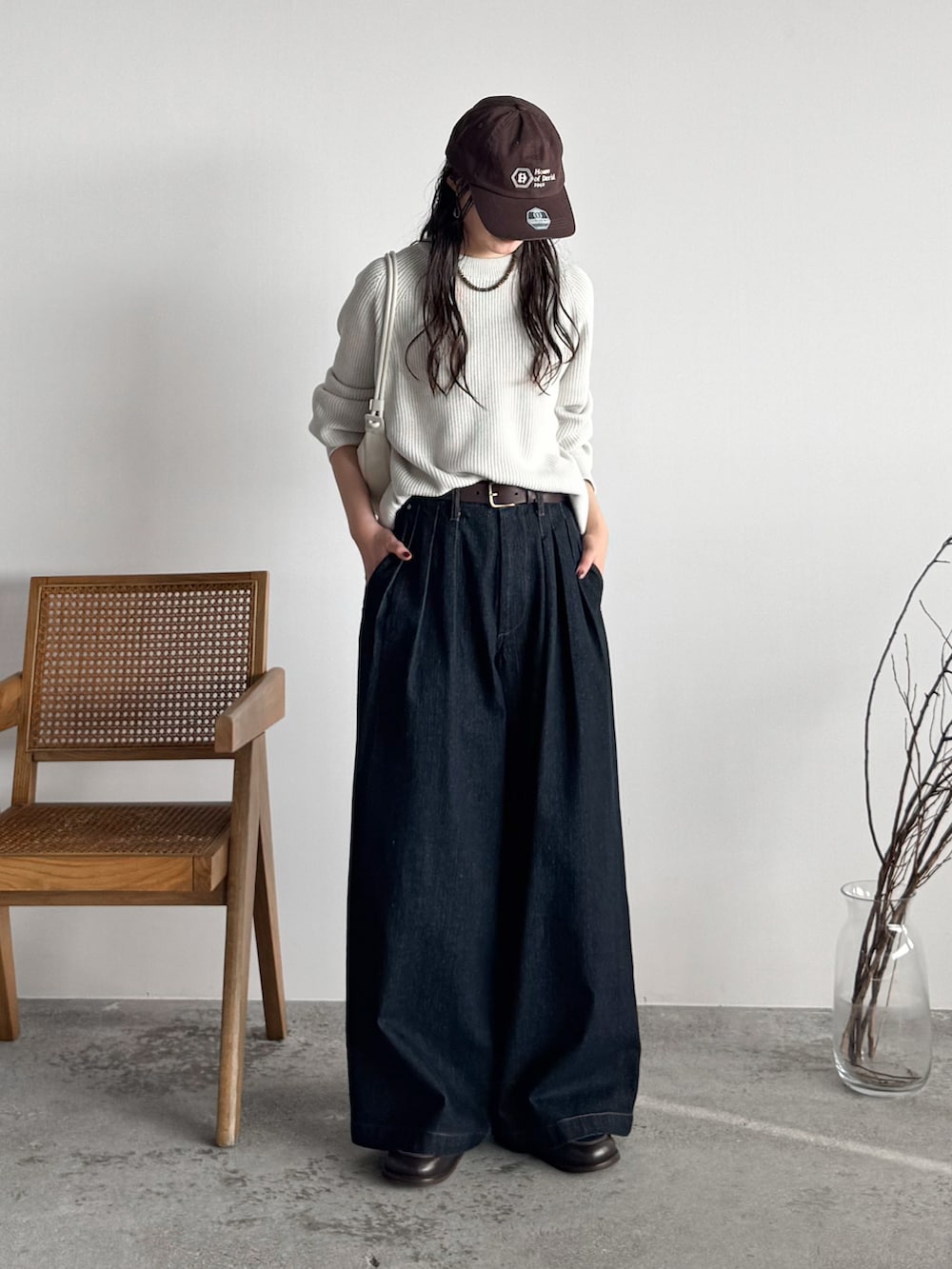 ブラウン系のローファー、ホワイト系のニット/セーター、ブルー系のデニムパンツを着用したレディースの秋コーディネートの2枚目の写真