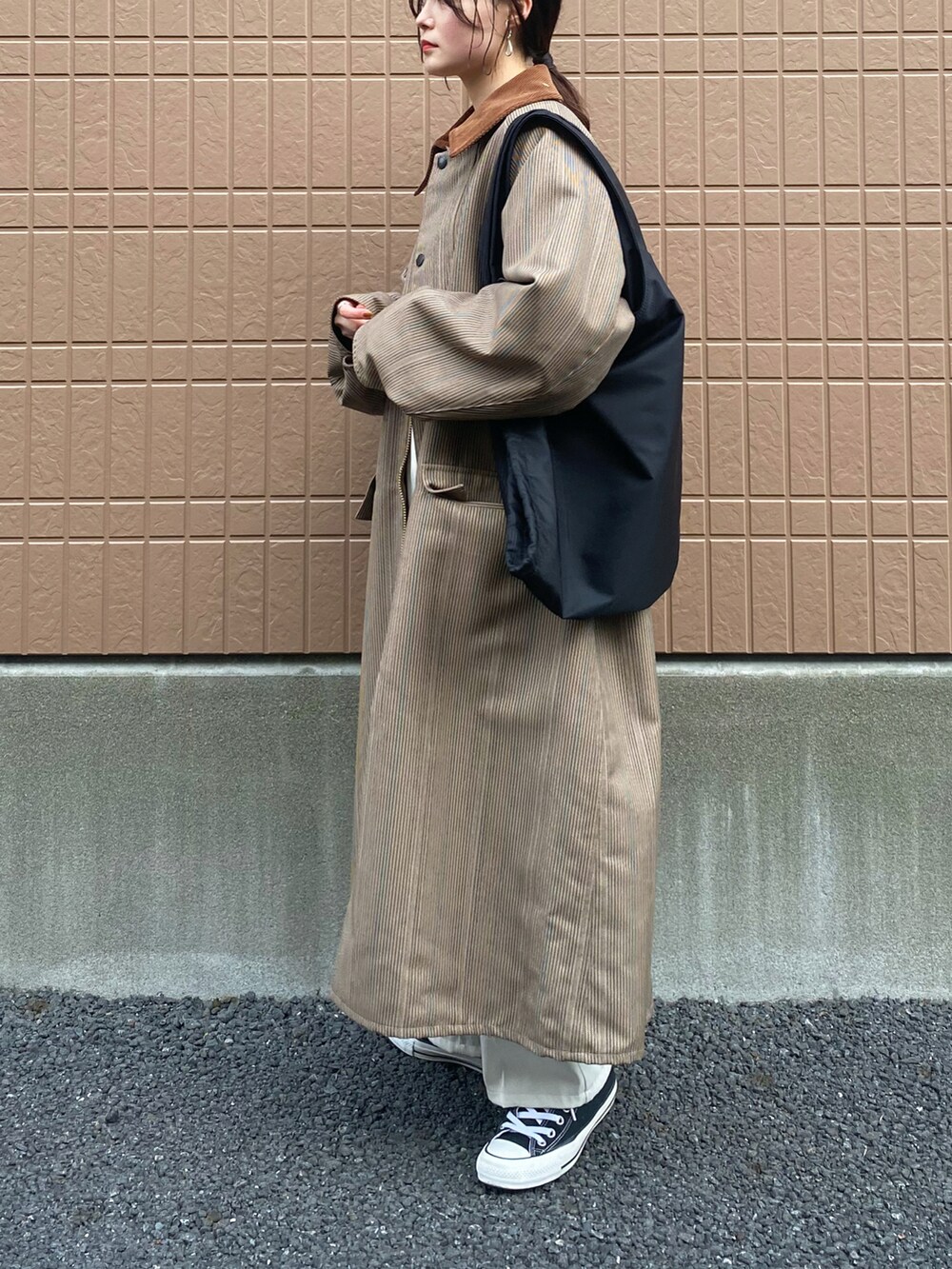 ベージュ系のその他アウター、ベージュ系のニット/セーター、ホワイト系のスラックスを着用したレディースの冬コーディネートの2枚目の写真