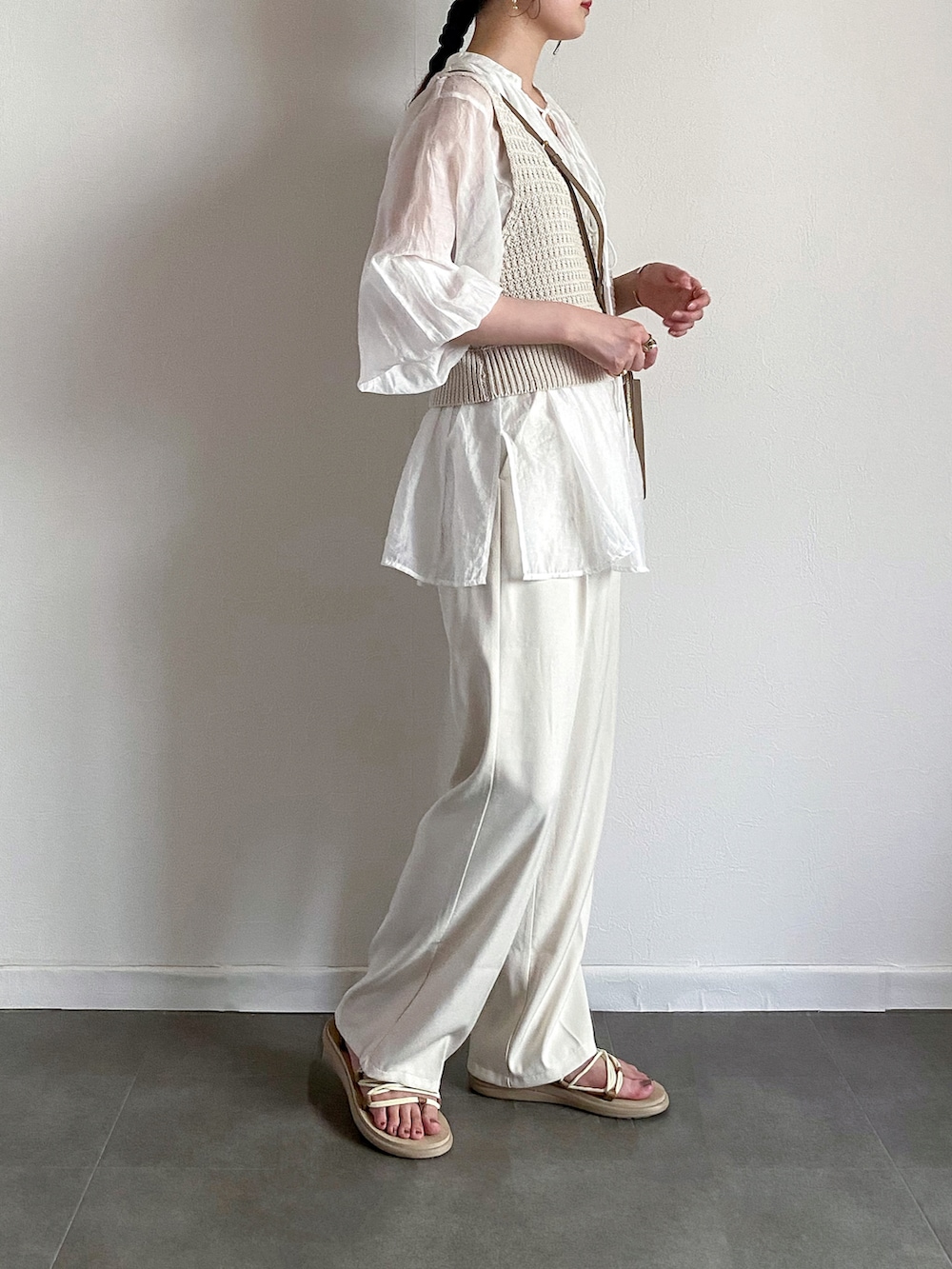 ホワイト系のシャツ/ブラウス、ホワイト系のスラックス、ベージュ系のショルダーバッグを着用したレディースの夏コーディネートの2枚目の写真