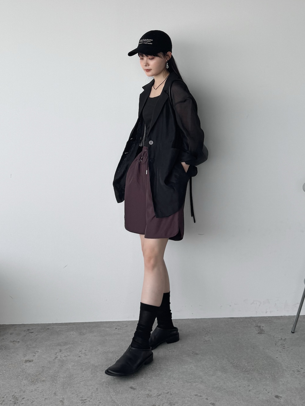 ブラック系のテーラードジャケット、レッド系のその他パンツ、ブラック系のショルダーバッグを着用したレディースの夏コーディネートの3枚目の写真