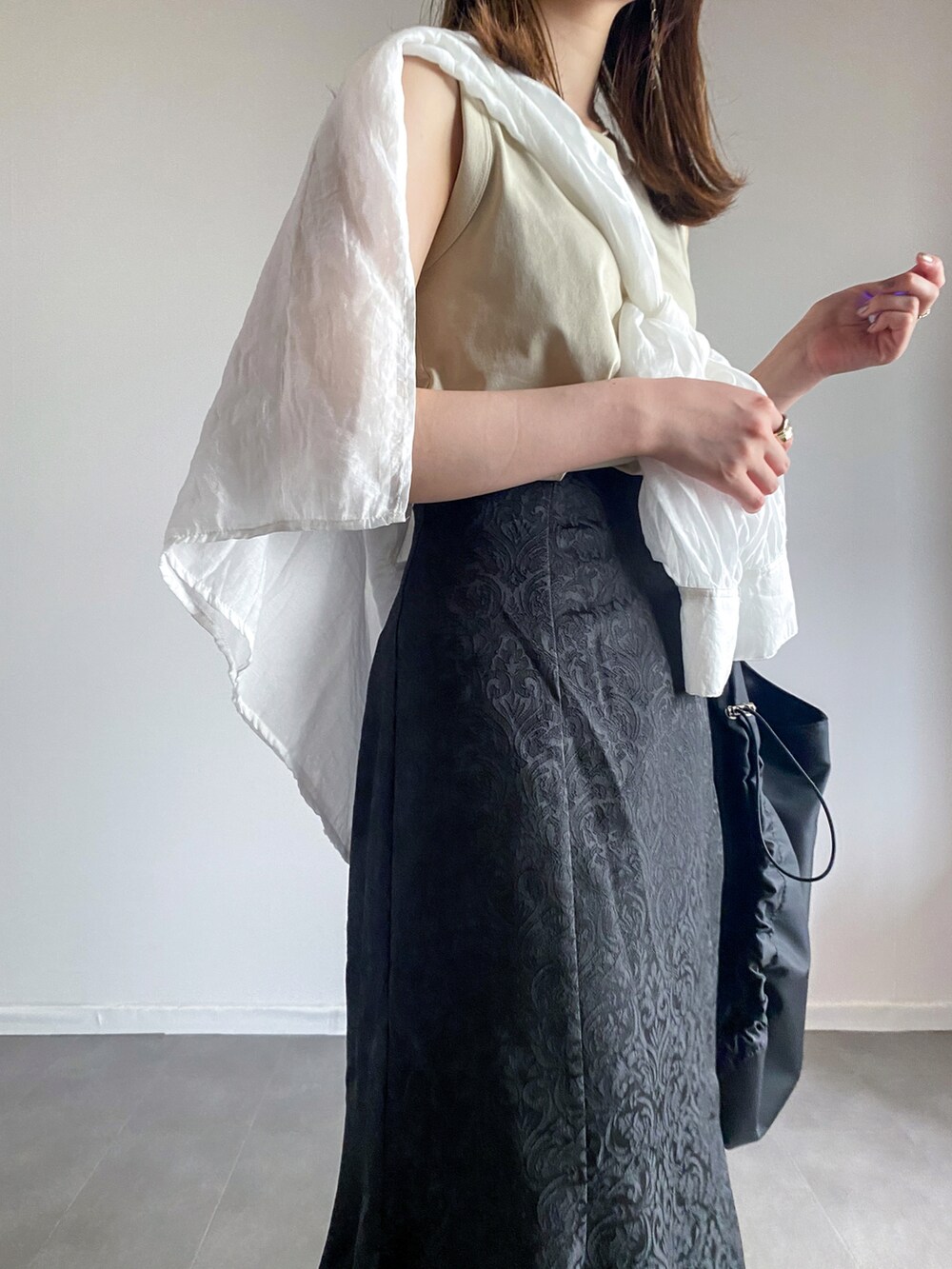 ブラック系のスカート、ホワイト系のTシャツ/カットソー、ホワイト系のシャツ/ブラウスを着用したレディースの夏コーディネートの3枚目の写真