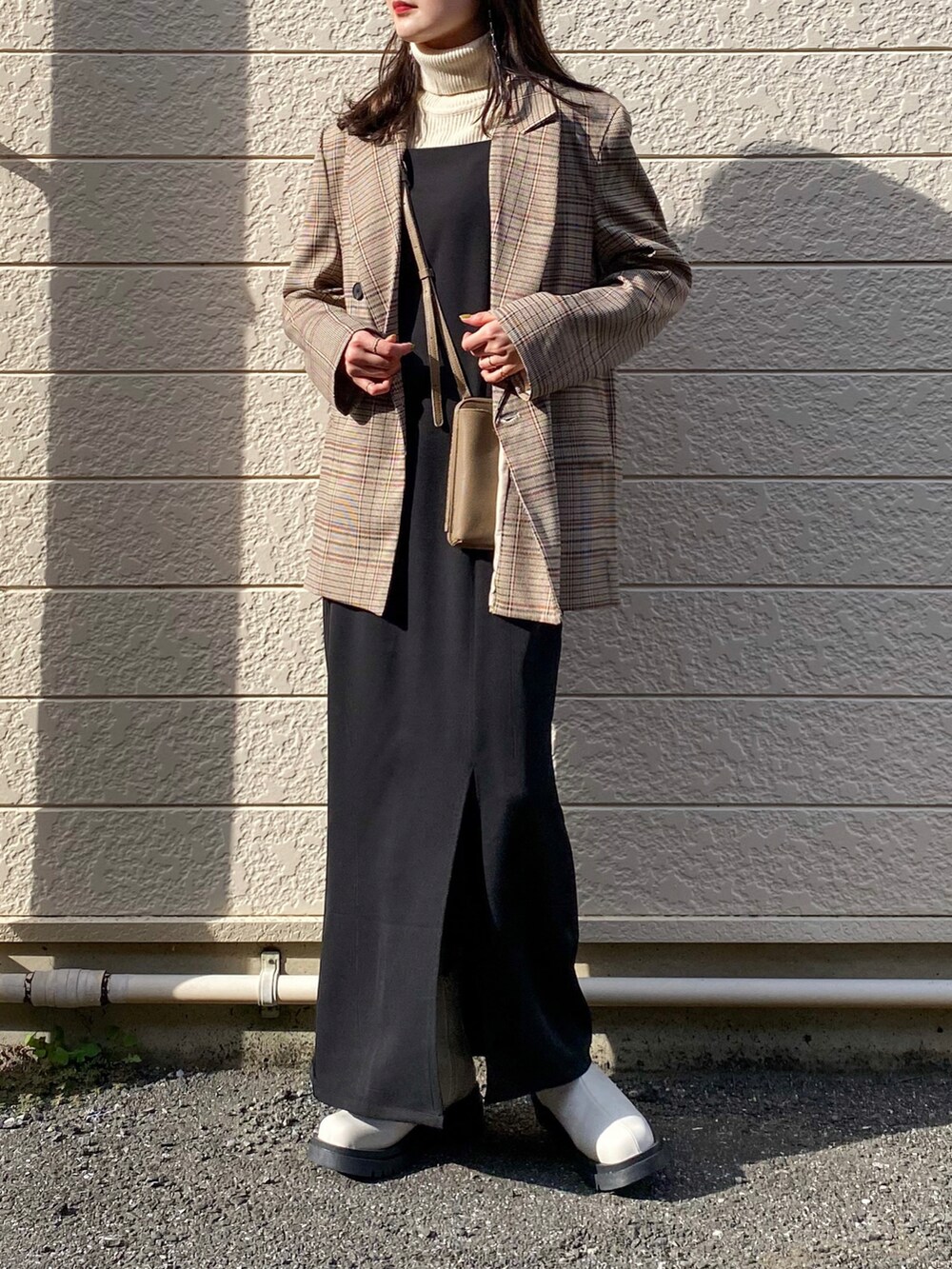 ブラウン系のテーラードジャケット、ブラック系のワンピース、ホワイト系のニット/セーターを着用したレディースの秋コーディネートの2枚目の写真