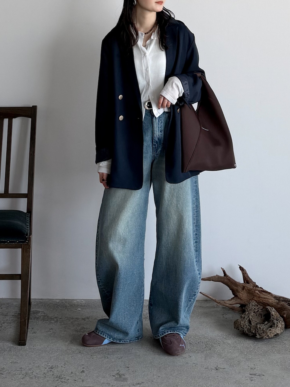 ブルー系のテーラードジャケット、ホワイト系のカーディガン/ボレロ、ブルー系のデニムパンツを着用したレディースの春コーディネートの2枚目の写真