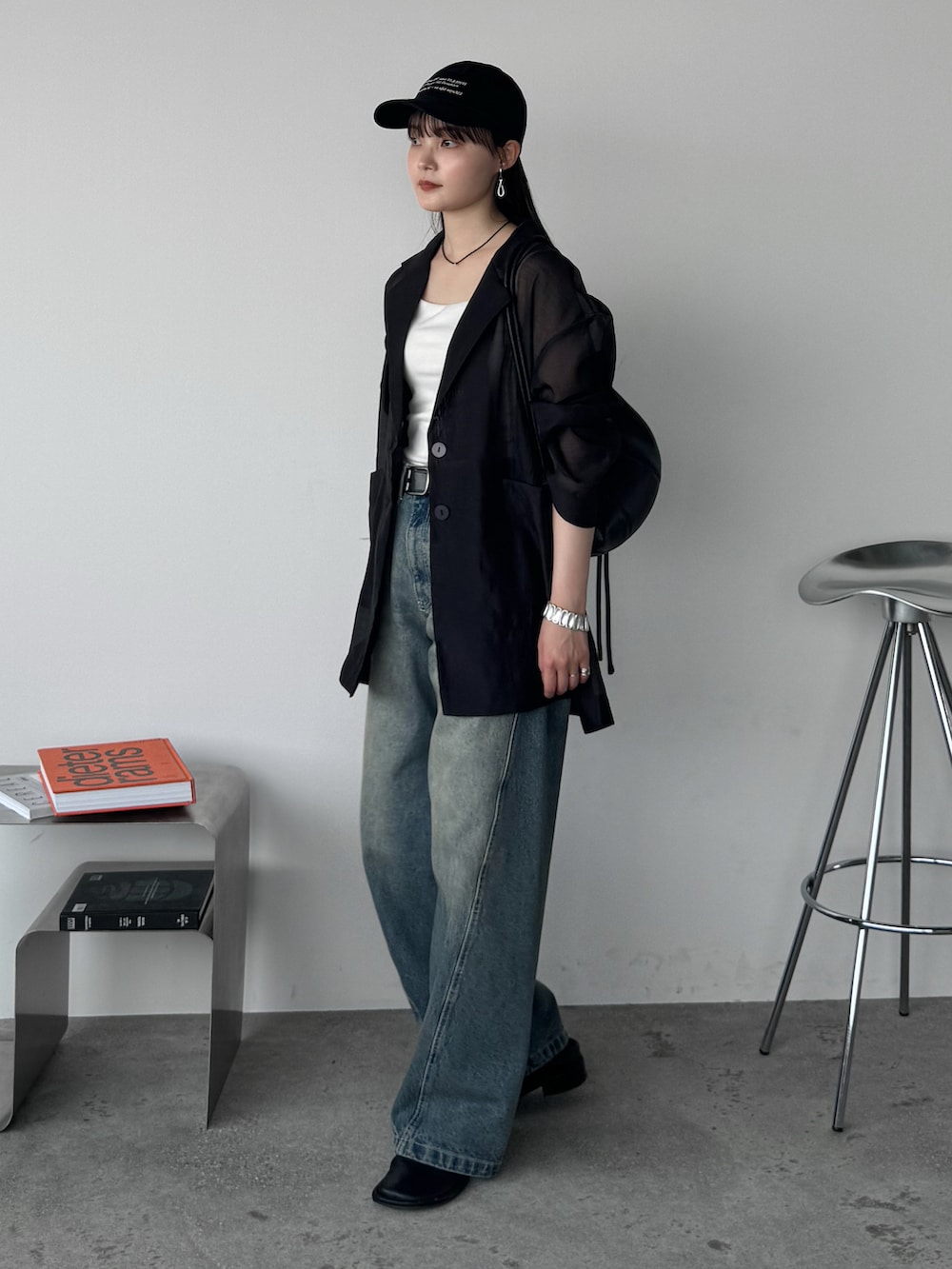 ブラック系のテーラードジャケット、ブルー系のデニムパンツ、ブラック系のショルダーバッグを着用したレディースの夏コーディネートの3枚目の写真