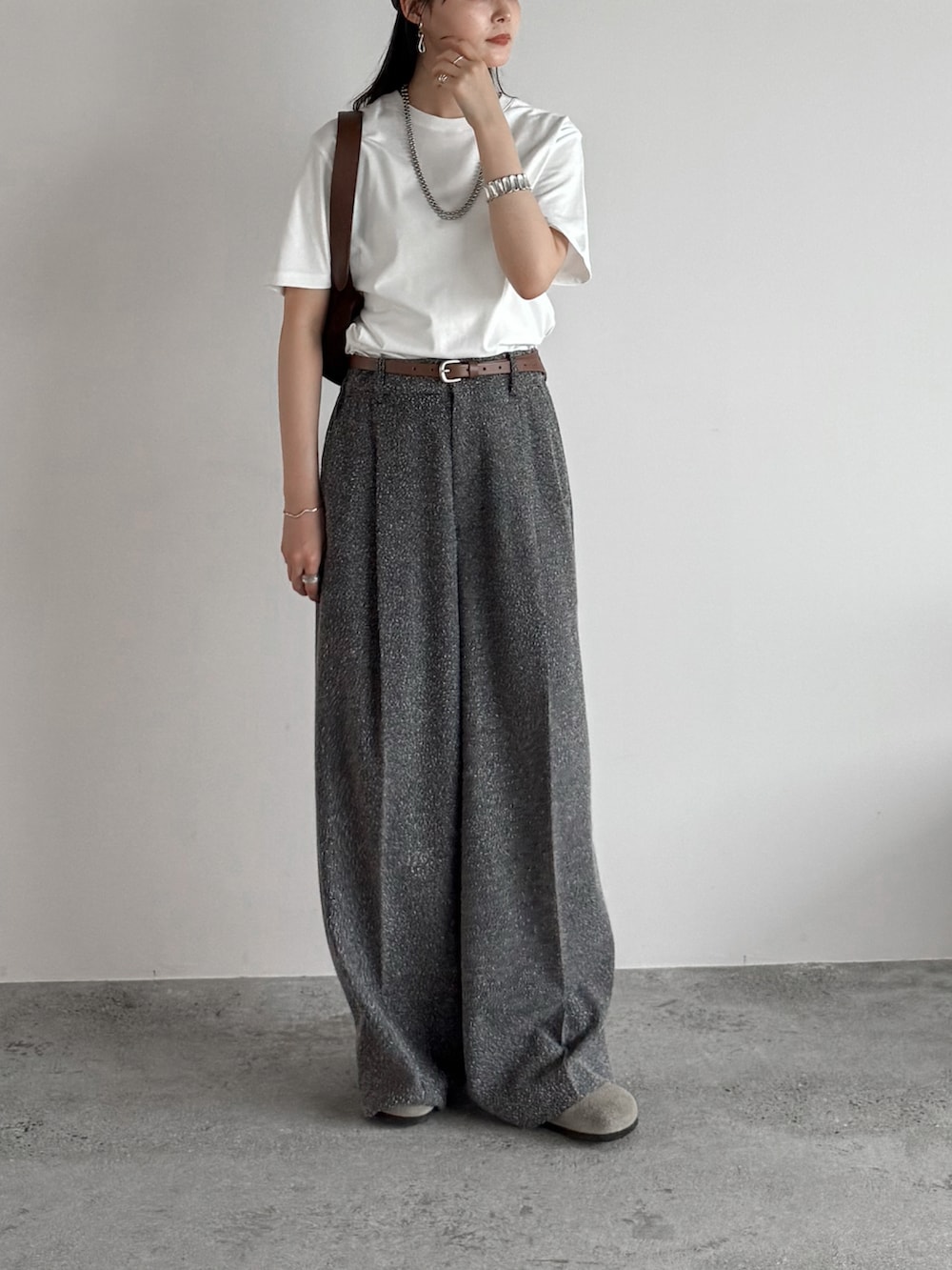 ベージュ系のサンダル、ホワイト系のTシャツ/カットソー、グレー系のスラックスを着用したレディースの夏コーディネートの2枚目の写真