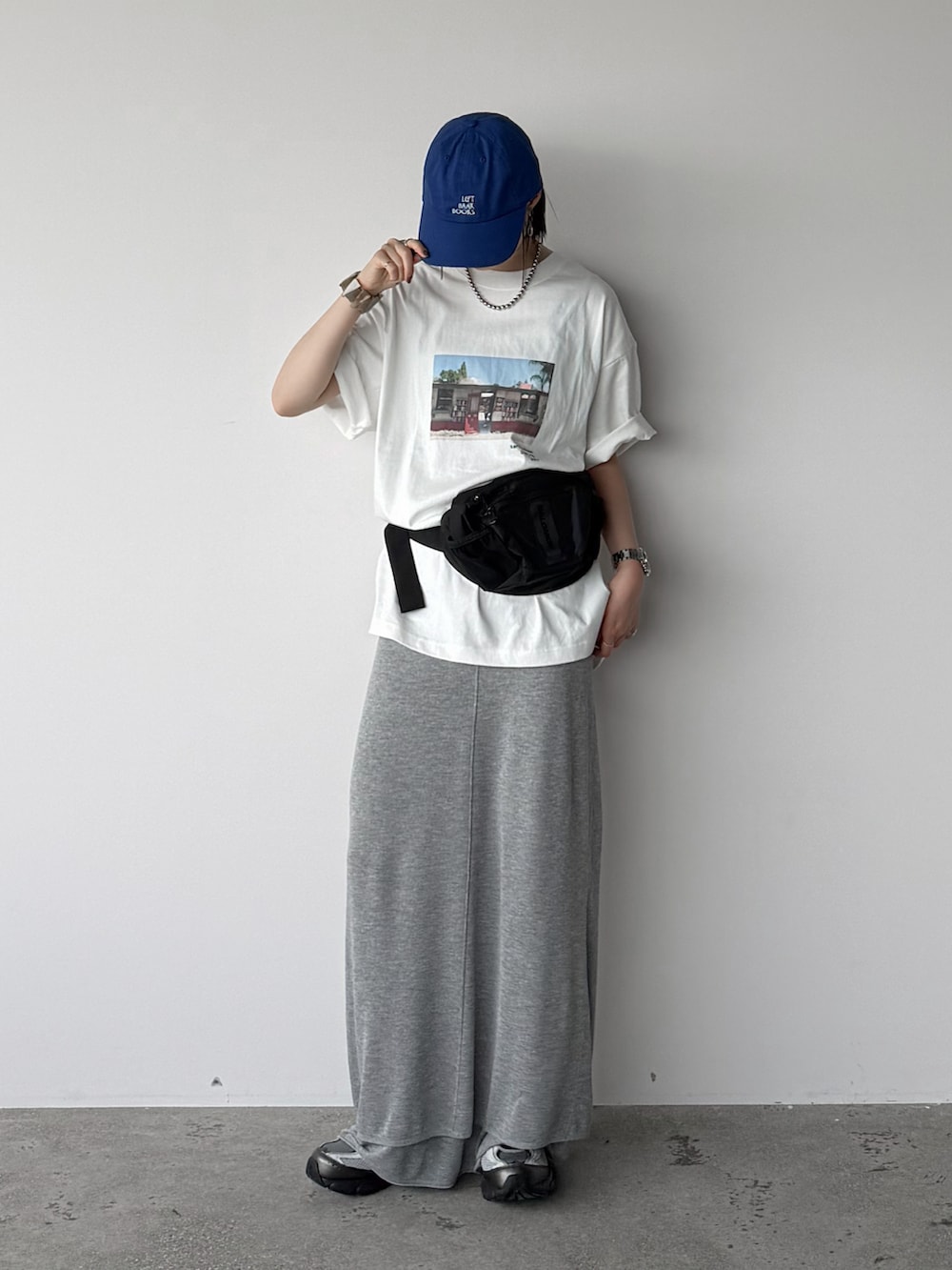 ホワイト系のTシャツ/カットソー、グレー系のスカート、ブラック系のボディバッグ/ウエストポーチを着用したレディースの夏コーディネートの2枚目の写真