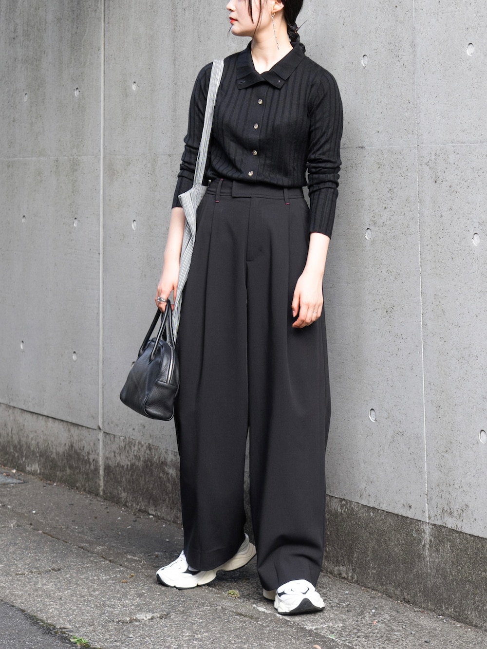 ブラック系のニット/セーター、ブラック系のその他パンツ、ブラック系のショルダーバッグを着用したレディースの秋コーディネートの5枚目の写真