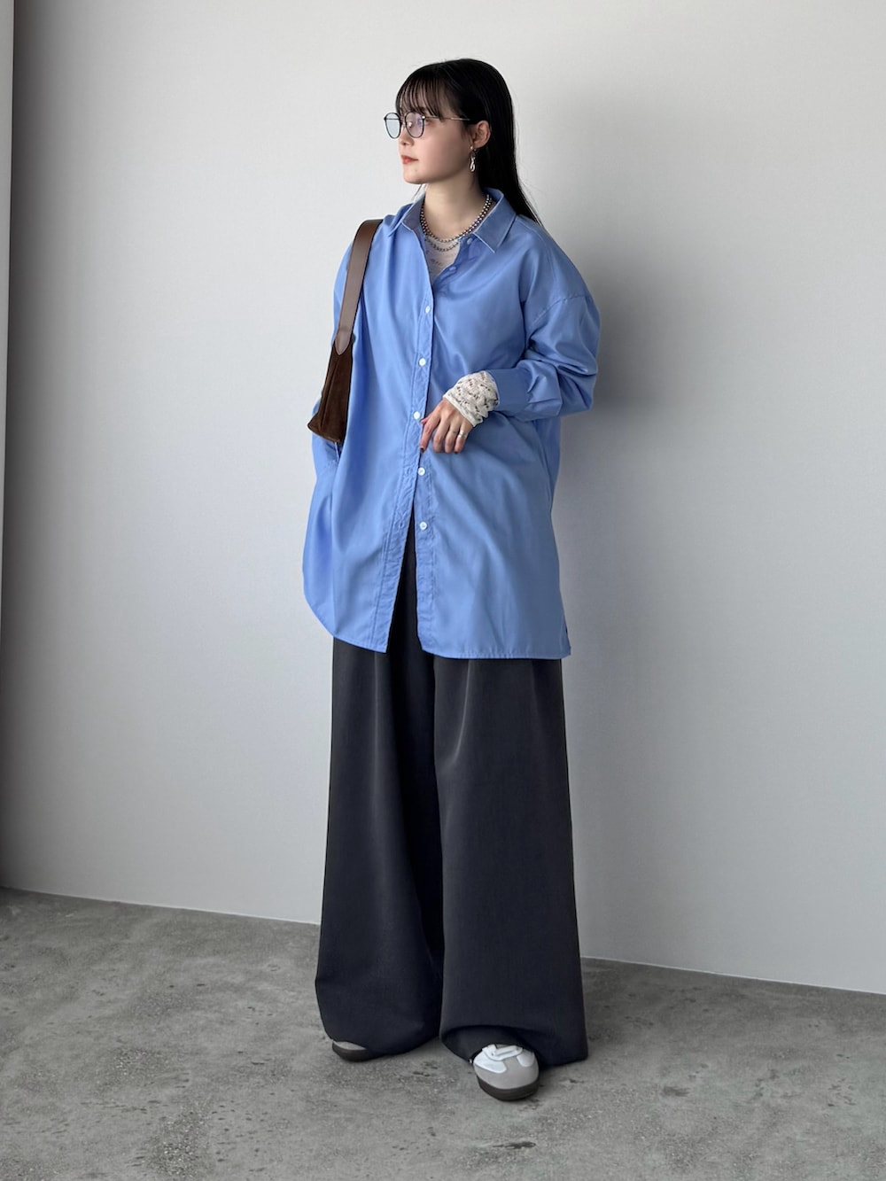 ブルー系のシャツ/ブラウス、ホワイト系のTシャツ/カットソー、グレー系のスラックスを着用したレディースの春コーディネートの2枚目の写真