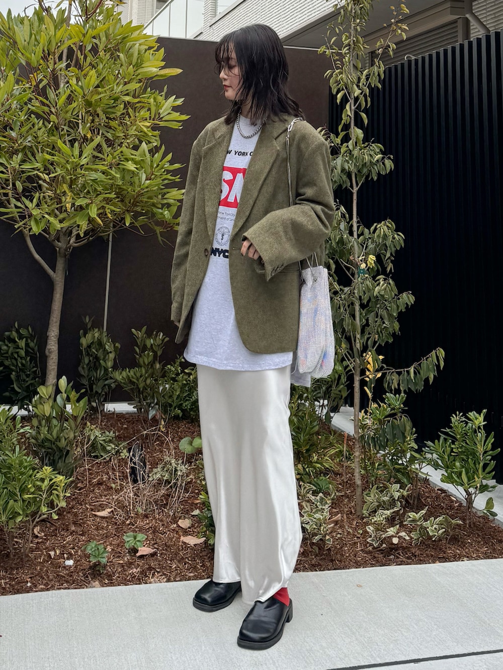 グリーン系のテーラードジャケット、グレー系のTシャツ/カットソー、ホワイト系のスカートを着用したレディースの春コーディネートの2枚目の写真