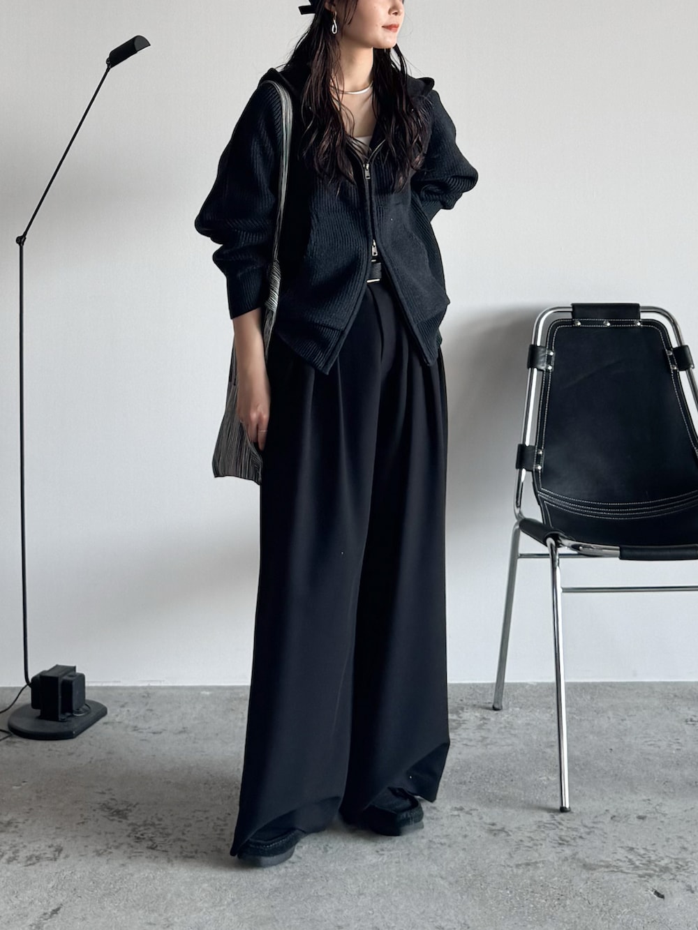 ブラック系のモカシン/デッキシューズ、グレー系のニット/セーター、ブラック系のスラックスを着用したレディースの秋コーディネートの3枚目の写真