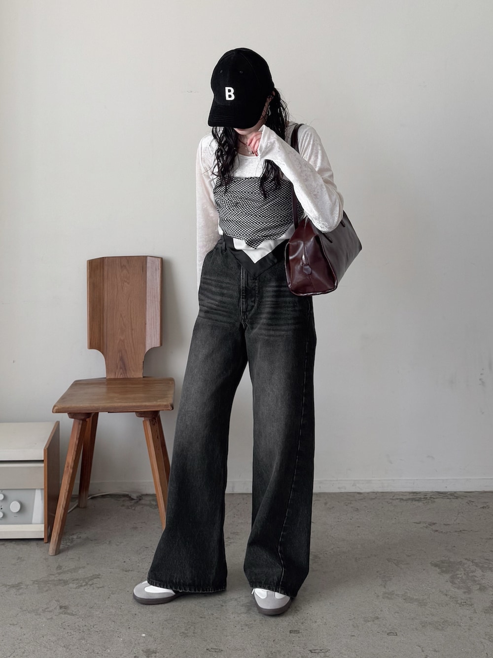 ホワイト系のTシャツ/カットソー、ブラック系のデニムパンツ、ブラウン系のボストンバッグを着用したレディースの冬コーディネートの2枚目の写真