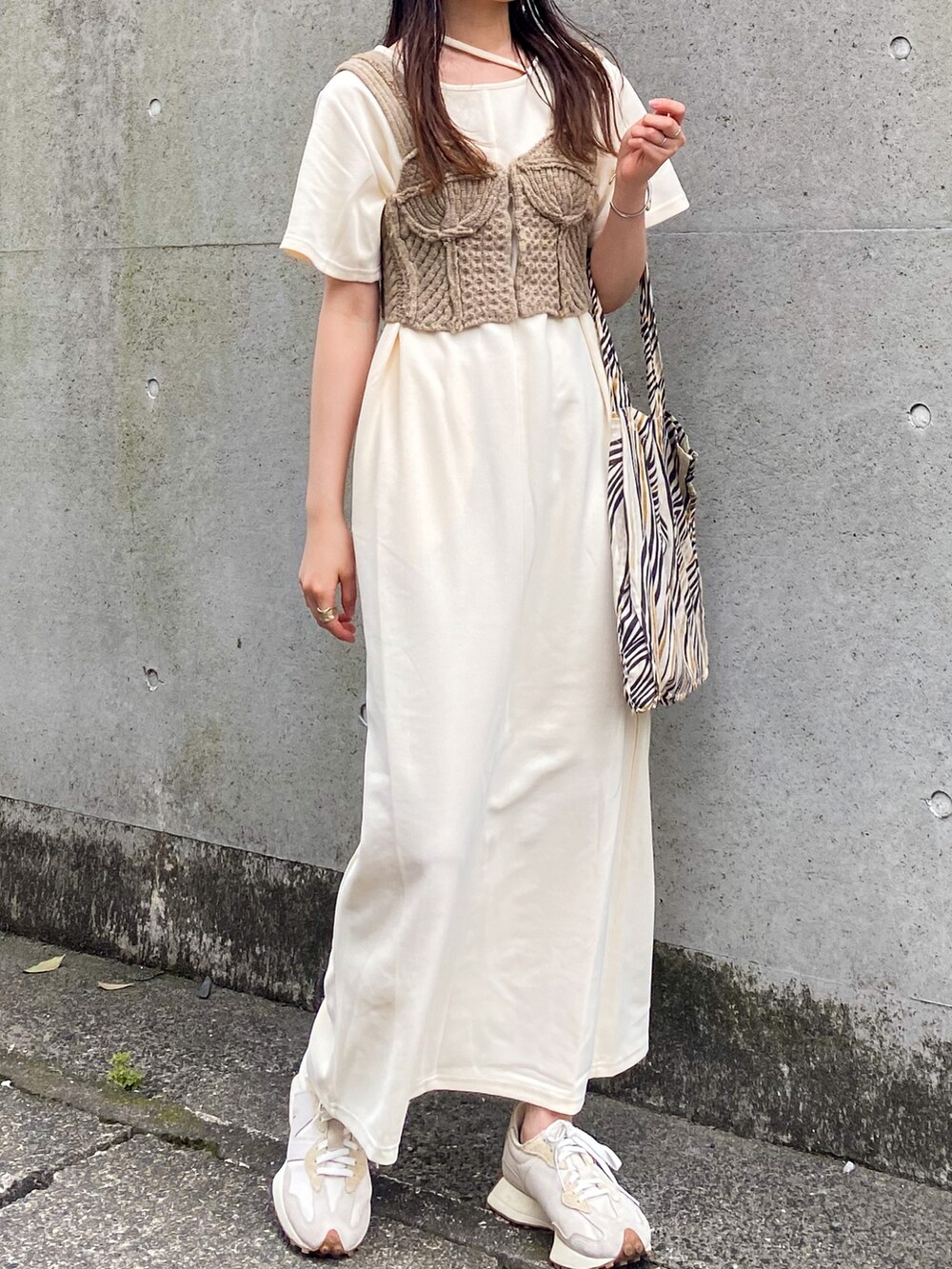 ホワイト系のワンピース、ベージュ系のベスト、ベージュ系のトートバッグを着用したレディースの夏コーディネートの2枚目の写真