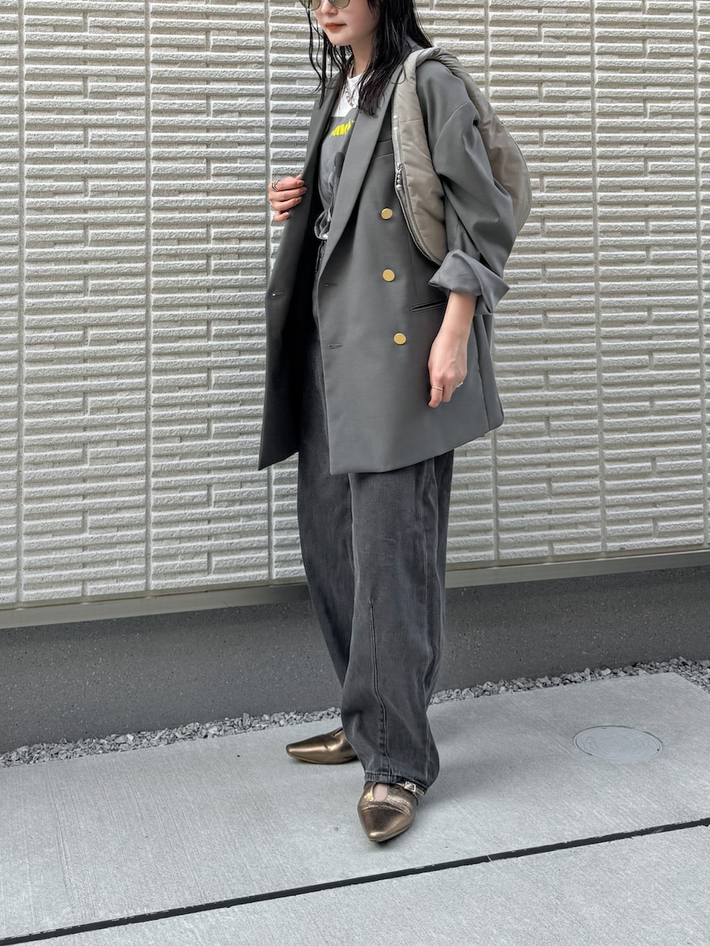 グレー系のテーラードジャケット、ホワイト系のTシャツ/カットソー、ブラック系のデニムパンツを着用したレディースの秋コーディネートの2枚目の写真