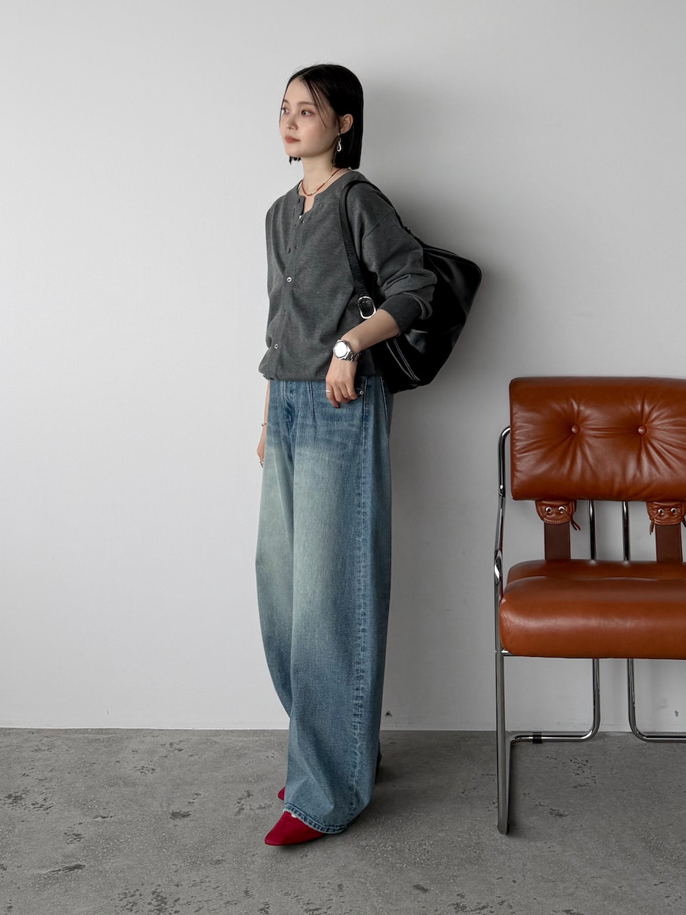 グレー系のカーディガン/ボレロ、ホワイト系のタンクトップ、ブルー系のデニムパンツを着用したレディースの秋コーディネートの2枚目の写真