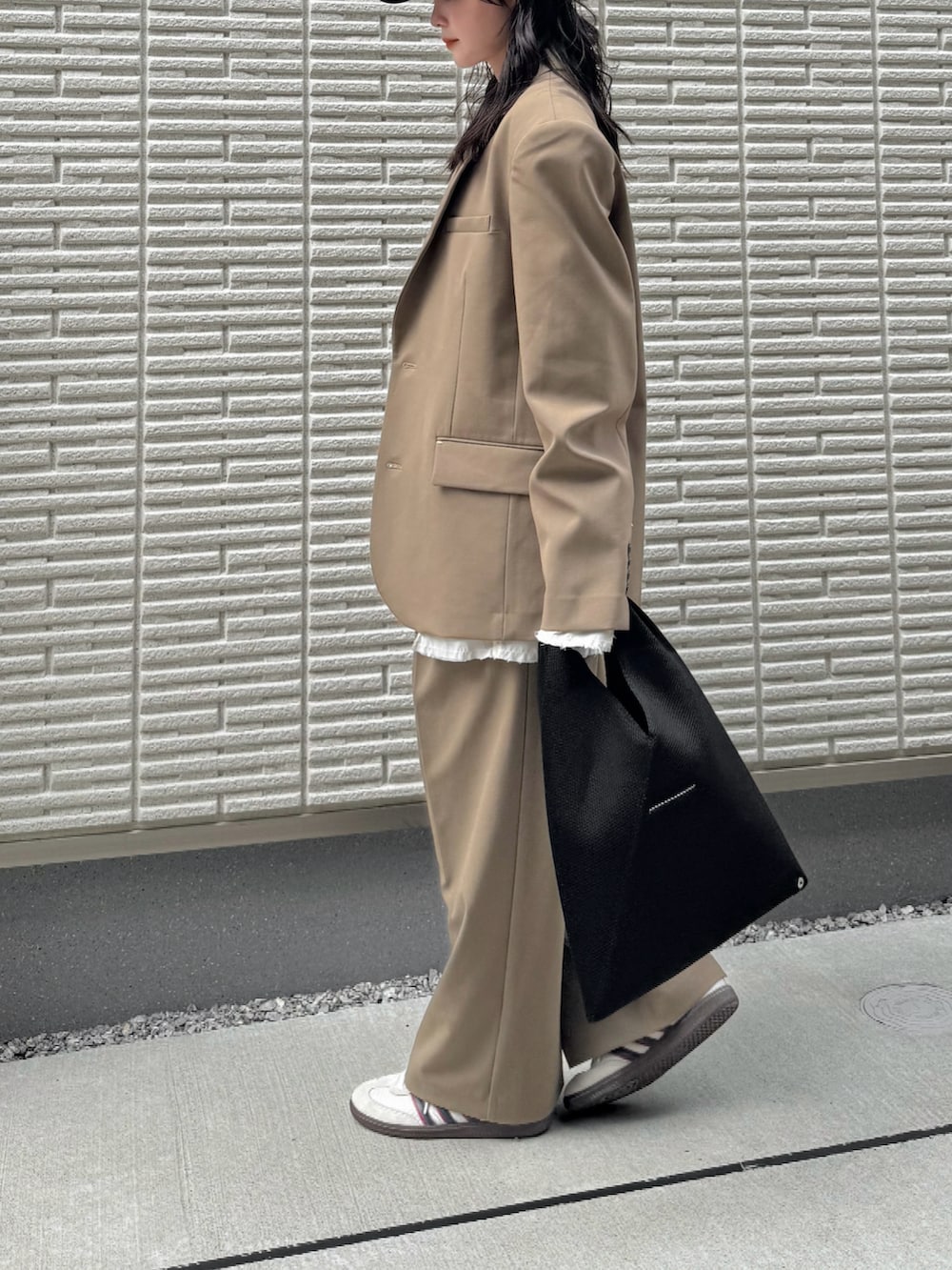 グリーン系のテーラードジャケット、ホワイト系のTシャツ/カットソー、グリーン系のスラックスを着用したレディースの秋コーディネートの2枚目の写真