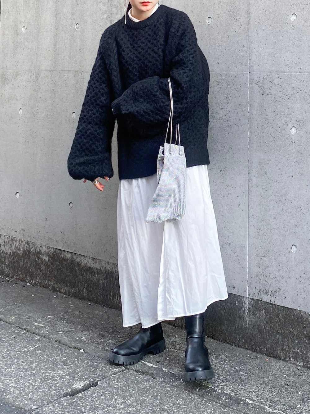 ブラック系のニット/セーター、ホワイト系のシャツワンピース、シルバー系のショルダーバッグを着用したレディースの秋コーディネートの2枚目の写真