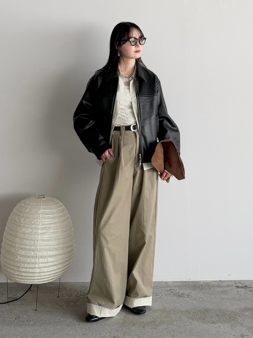 ベージュ系のスラックス、その他のシャツ/ブラウス、ブラック系のブルゾンを着用したレディースの春コーディネートの2枚目の写真