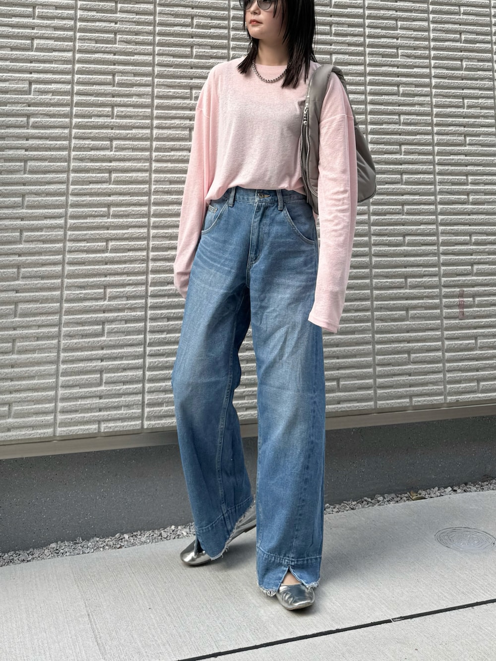 ピンク系のTシャツ/カットソー、ブルー系のデニムパンツ、グレー系のハンドバッグを着用したレディースの冬コーディネートの3枚目の写真