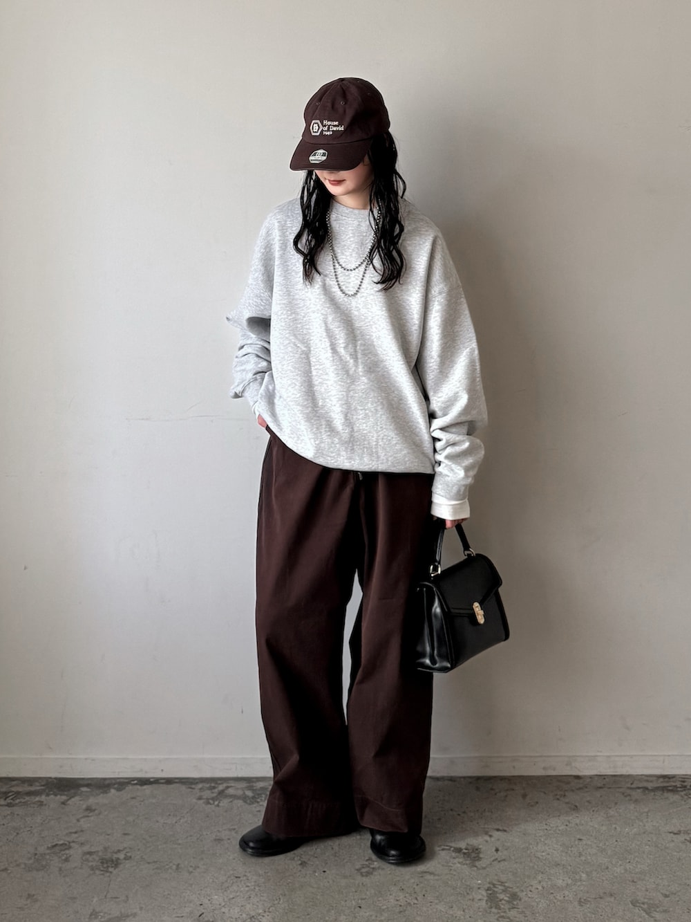 グレー系のスウェット、ホワイト系のTシャツ/カットソー、レッド系のチノパンツを着用したレディースの春コーディネートの3枚目の写真