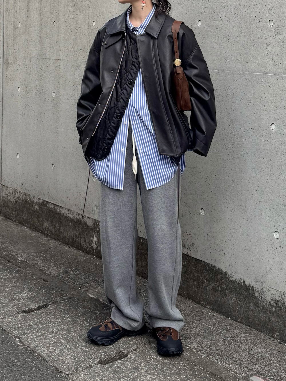 ブラウン系のブルゾン、ブルー系のシャツ/ブラウス、グレー系のスウェットパンツを着用したレディースの冬コーディネートの2枚目の写真