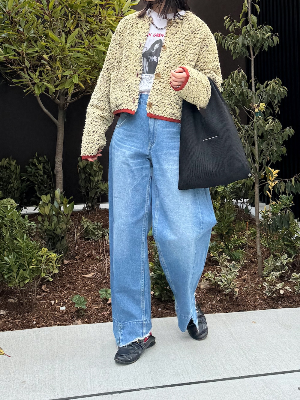 ベージュ系のカーディガン/ボレロ、ホワイト系のTシャツ/カットソー、ブルー系のデニムパンツを着用したレディースの冬コーディネートの3枚目の写真