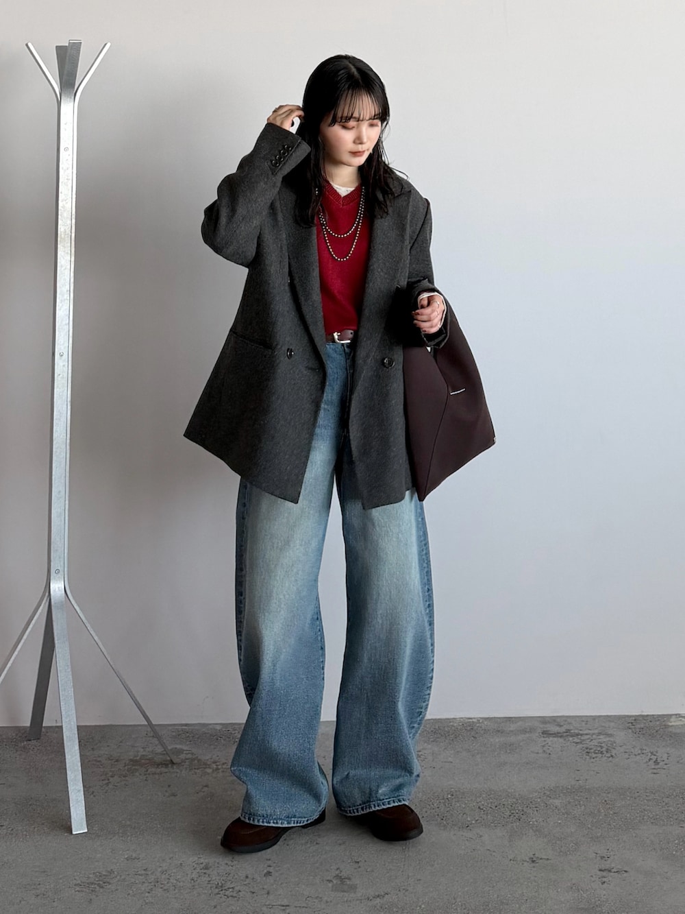 グリーン系のテーラードジャケット、ブラウン系のローファー、その他のハンドバッグを着用したレディースの冬コーディネートの2枚目の写真