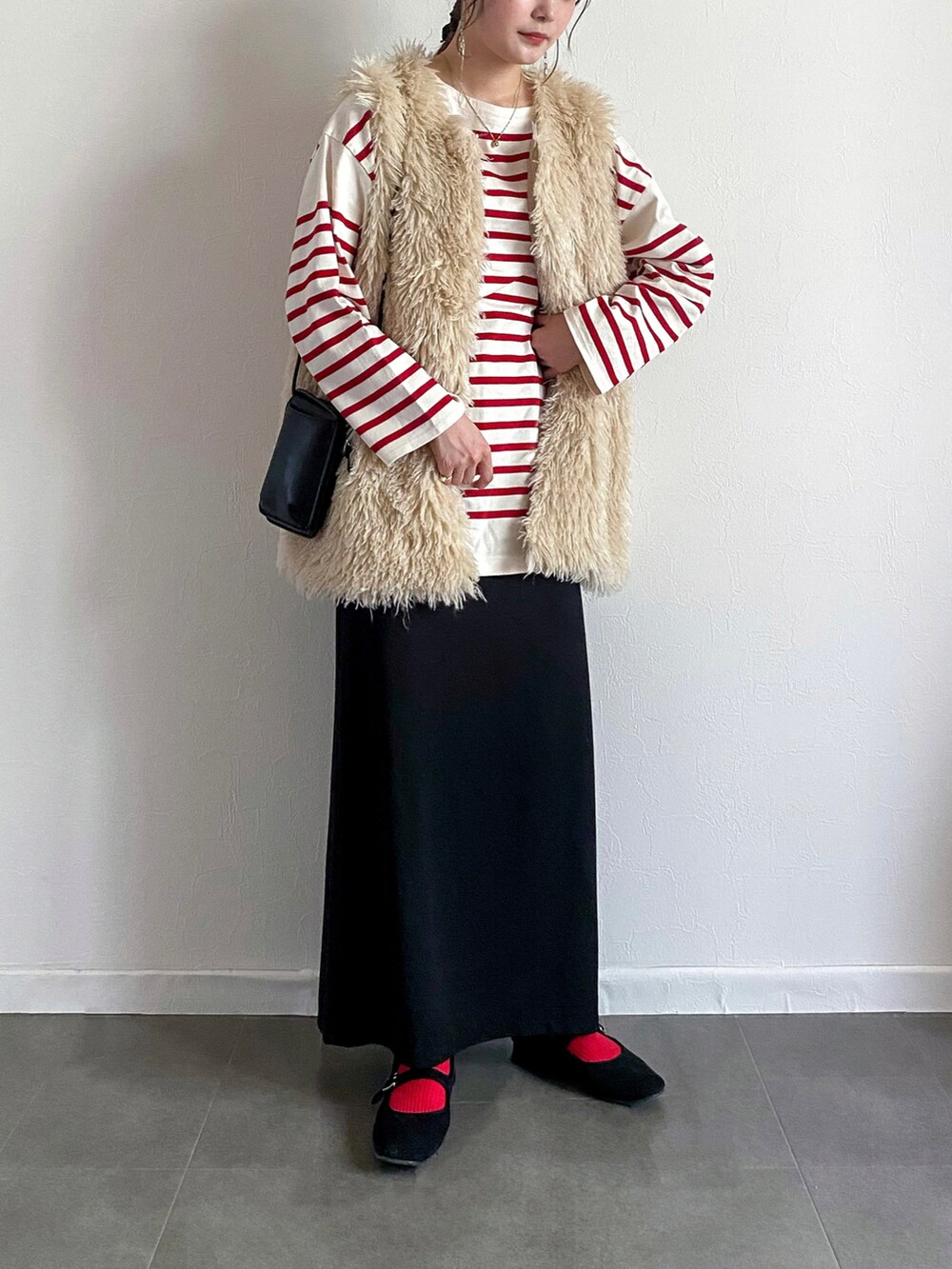 ホワイト系のベスト、レッド系のTシャツ/カットソー、ブラック系のショルダーバッグを着用したレディースの秋コーディネートの2枚目の写真