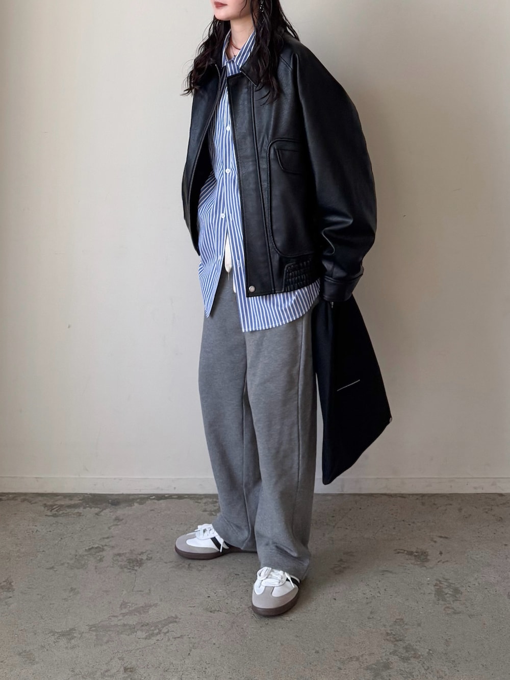 ブラック系のブルゾン、ブルー系のシャツ/ブラウス、グレー系のスウェットパンツを着用したレディースの冬コーディネートの3枚目の写真