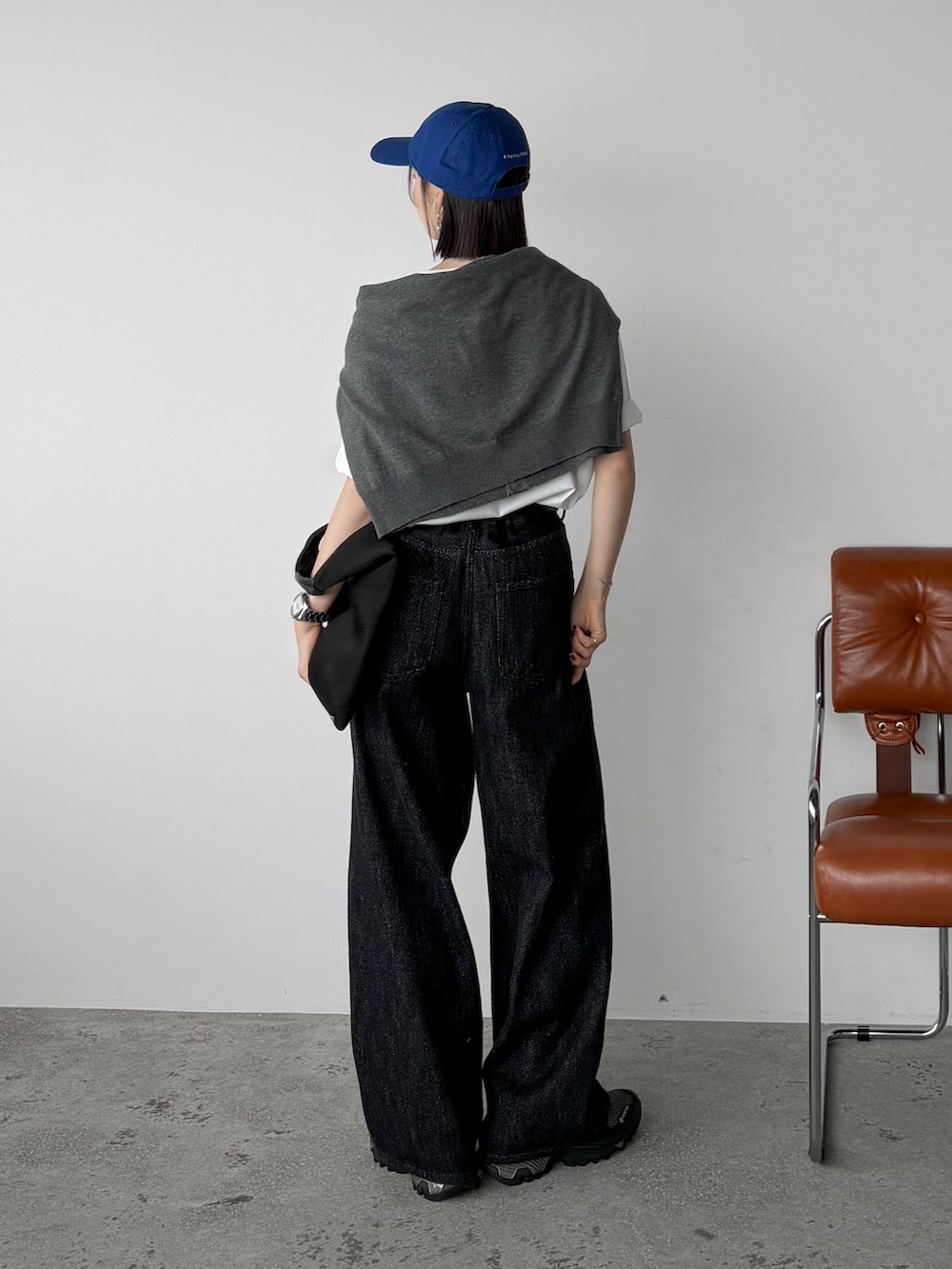 ホワイト系のTシャツ/カットソー、ブラック系のデニムパンツ、ブラック系のスニーカーを着用したレディースの秋コーディネートの3枚目の写真