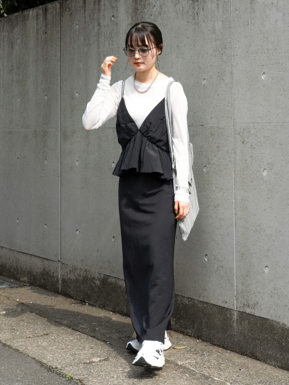 ブラック系のトップス、ホワイト系のTシャツ/カットソー、ホワイト系のスニーカーを着用したレディースの秋コーディネートの4枚目の写真