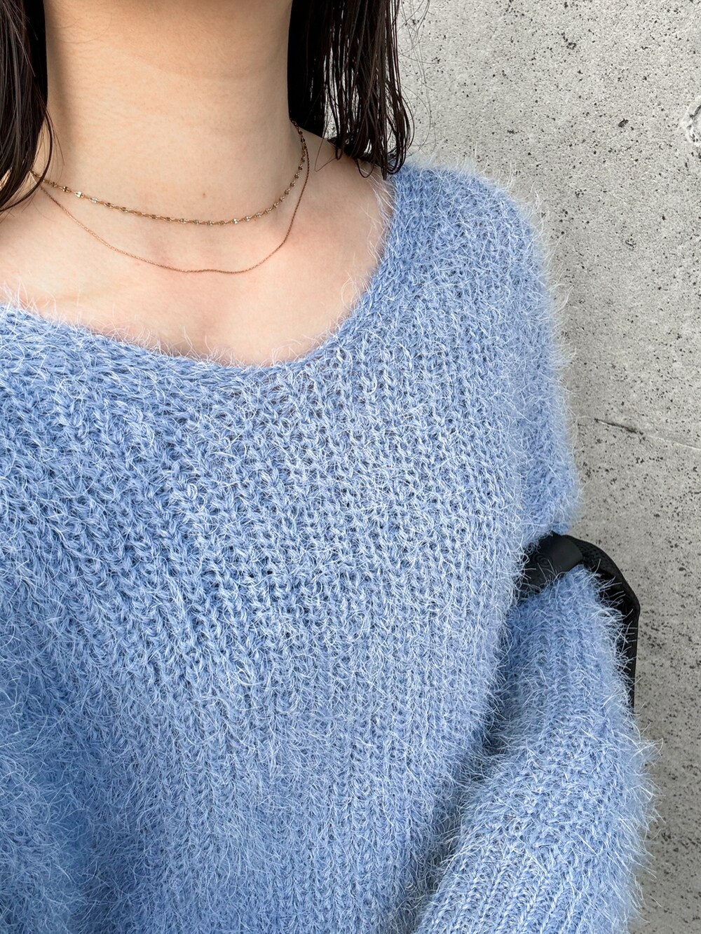 ブルー系のニット/セーター、ブラウン系のその他パンツ、ブラック系のトートバッグを着用したレディースの冬コーディネートの2枚目の写真