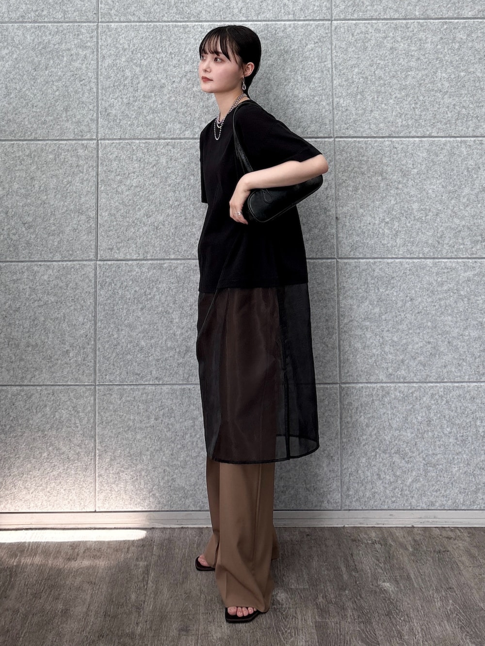 ブラック系のハンドバッグ、ブラック系のTシャツ/カットソー、イエロー系のその他パンツを着用したレディースの夏コーディネートの3枚目の写真