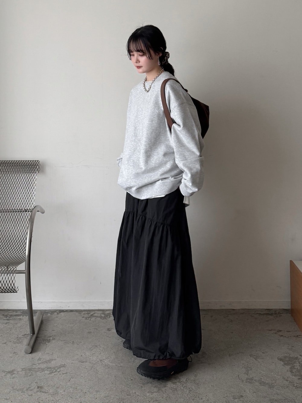 グレー系のスウェット、ホワイト系のTシャツ/カットソー、ブラック系のスカートを着用したレディースの春コーディネートの3枚目の写真