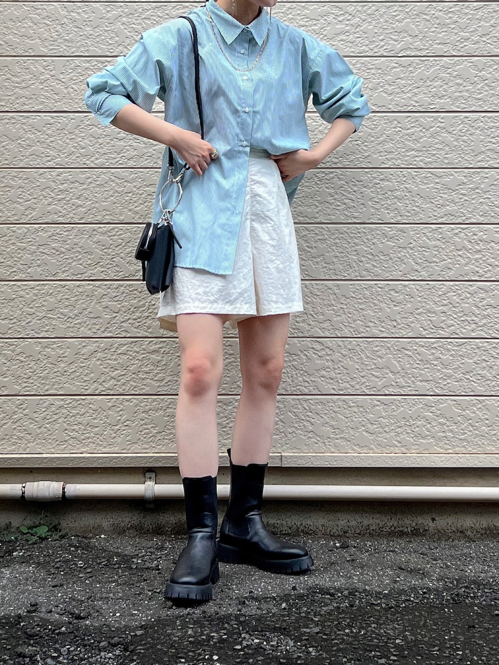 ブラック系のショルダーバッグ、グリーン系のシャツ/ブラウス、ホワイト系のパンツを着用したレディースの夏コーディネートの2枚目の写真