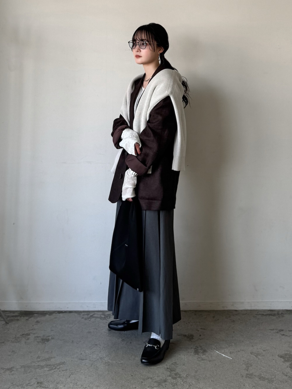 ブラウン系のテーラードジャケット、ホワイト系のTシャツ/カットソー、ホワイト系のニット/セーターを着用したレディースの春コーディネートの2枚目の写真