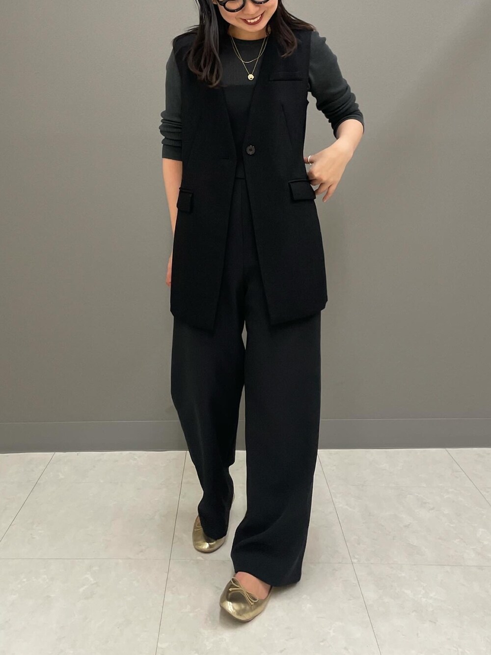 ブラック系のベスト、グレー系のニット/セーター、ブラック系のつなぎ/オールインワンを着用したレディースの冬コーディネートの4枚目の写真