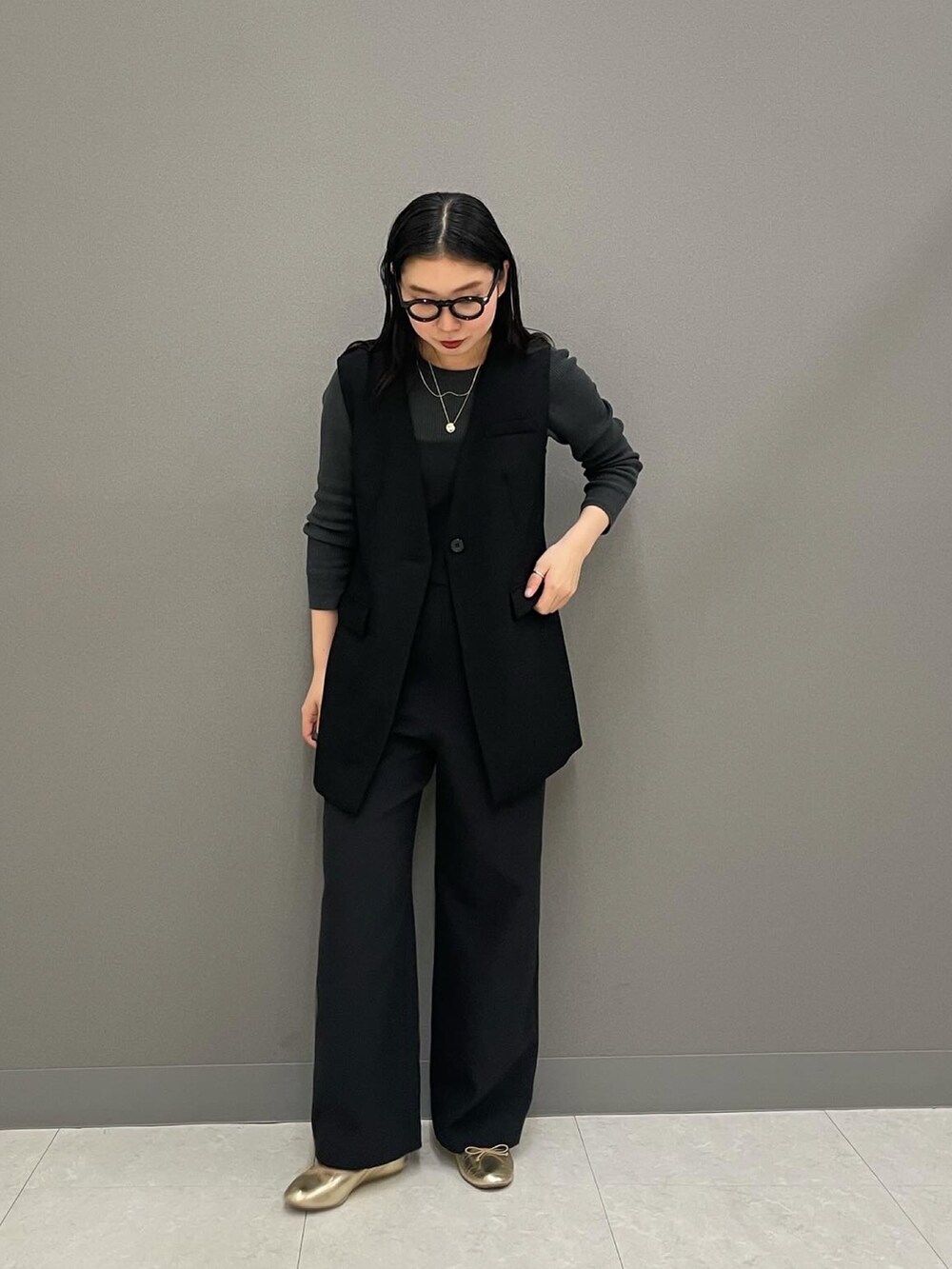 ブラック系のベスト、グレー系のニット/セーター、ブラック系のつなぎ/オールインワンを着用したレディースの冬コーディネートの2枚目の写真