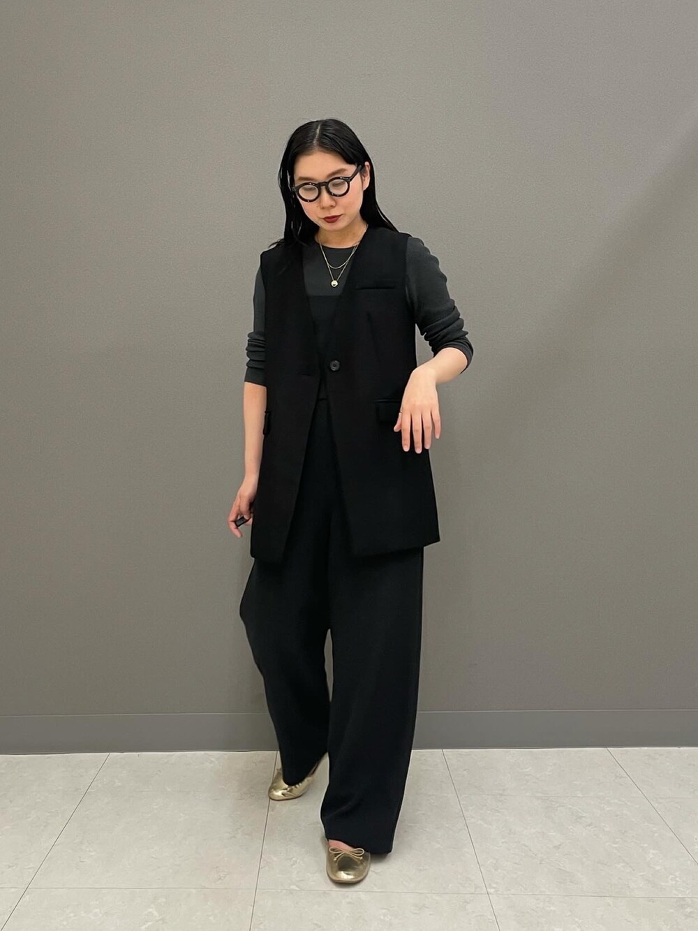 ブラック系のベスト、グレー系のニット/セーター、ブラック系のつなぎ/オールインワンを着用したレディースの冬コーディネートの3枚目の写真