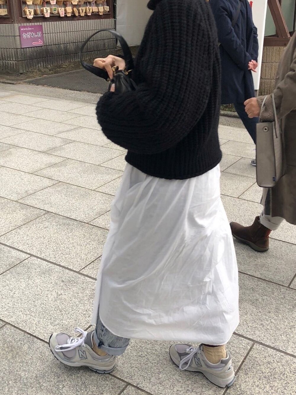 ブラック系のトートバッグ、グレー系のスニーカーを着用したレディースの冬コーディネートの2枚目の写真