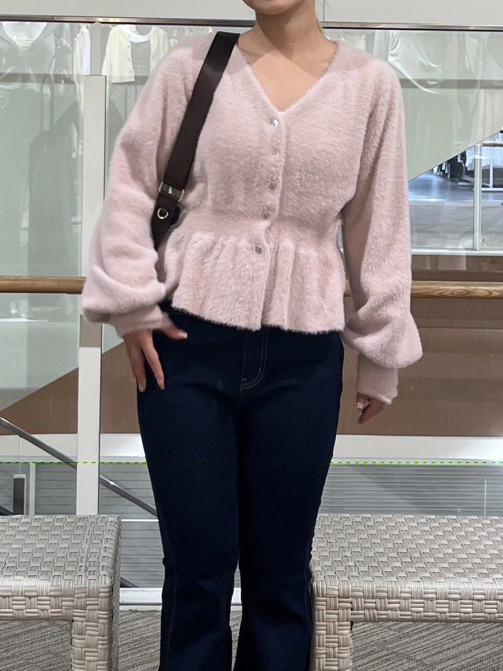 ブルー系のデニムパンツ、ブラウン系のショルダーバッグ、ピンク系のニット/セーターを着用したレディースの秋コーディネートの4枚目の写真