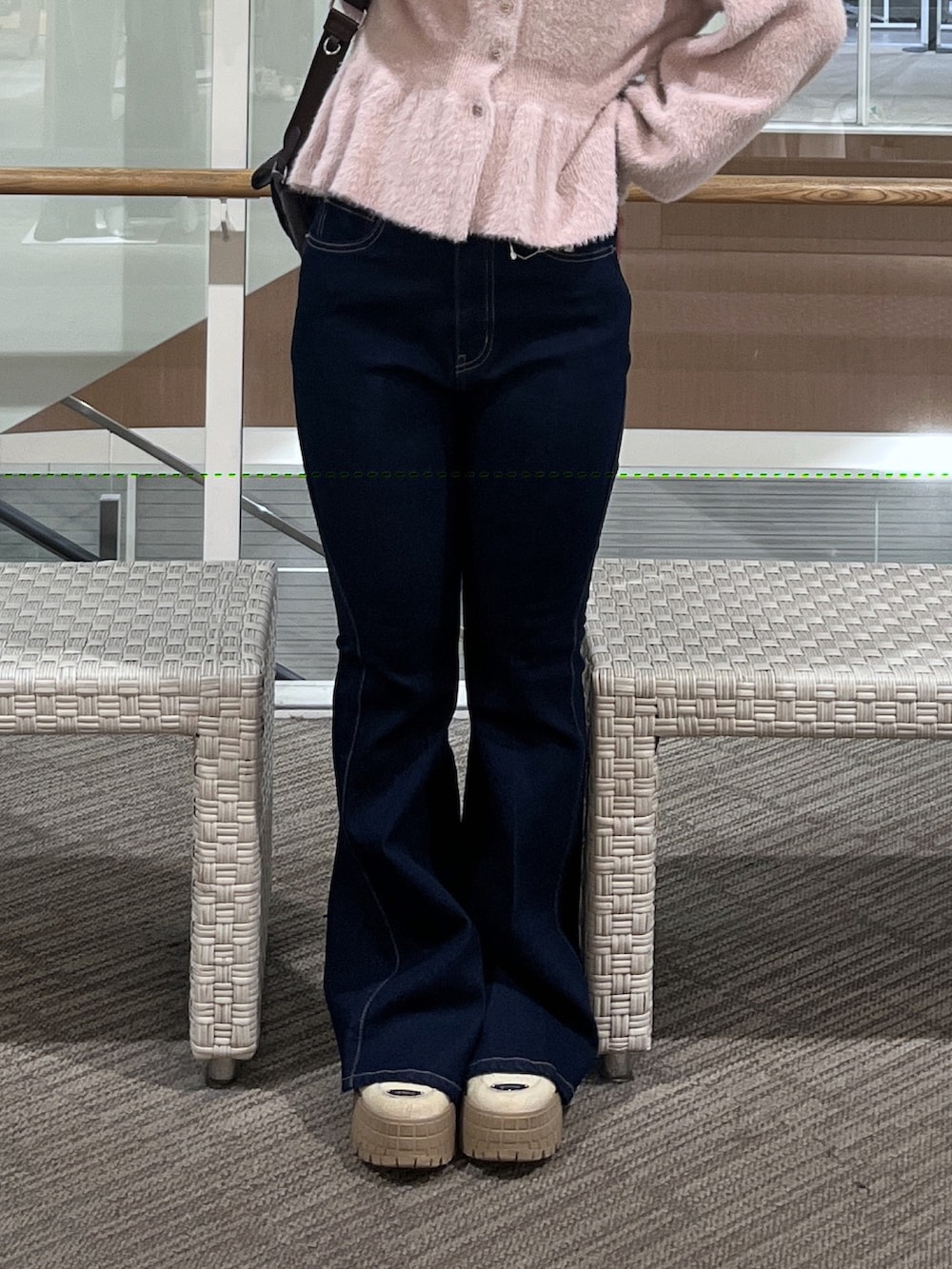 ブルー系のデニムパンツ、ブラウン系のショルダーバッグ、ピンク系のニット/セーターを着用したレディースの秋コーディネートの5枚目の写真