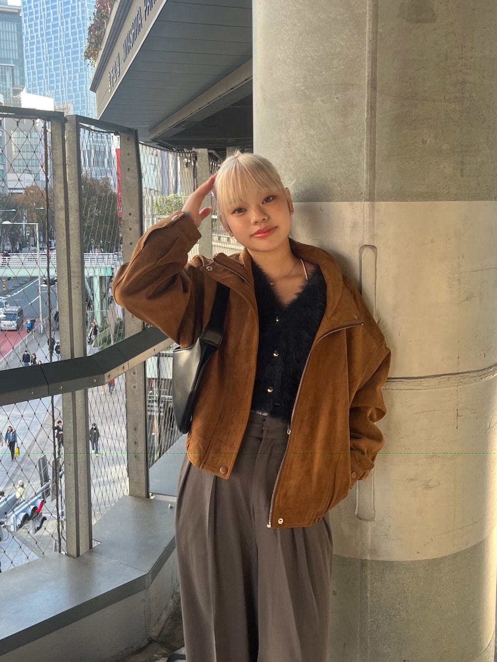 グレー系のスラックス、ブラウン系のブルゾン、ブルー系のニット/セーターを着用したレディースの秋コーディネートの4枚目の写真