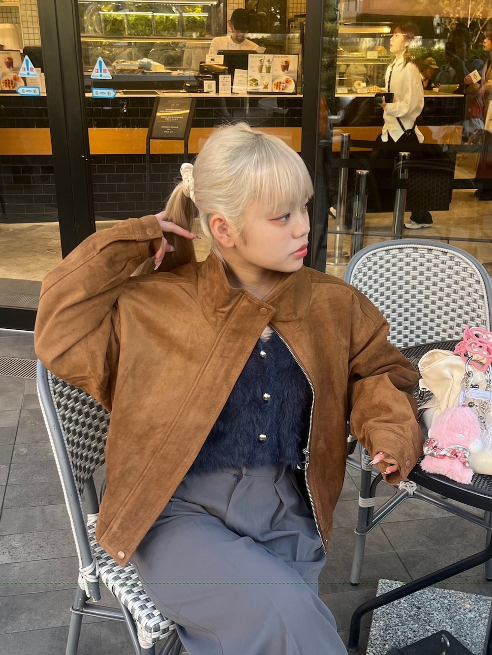 グレー系のスラックス、ブラウン系のブルゾン、ブルー系のニット/セーターを着用したレディースの秋コーディネートの5枚目の写真