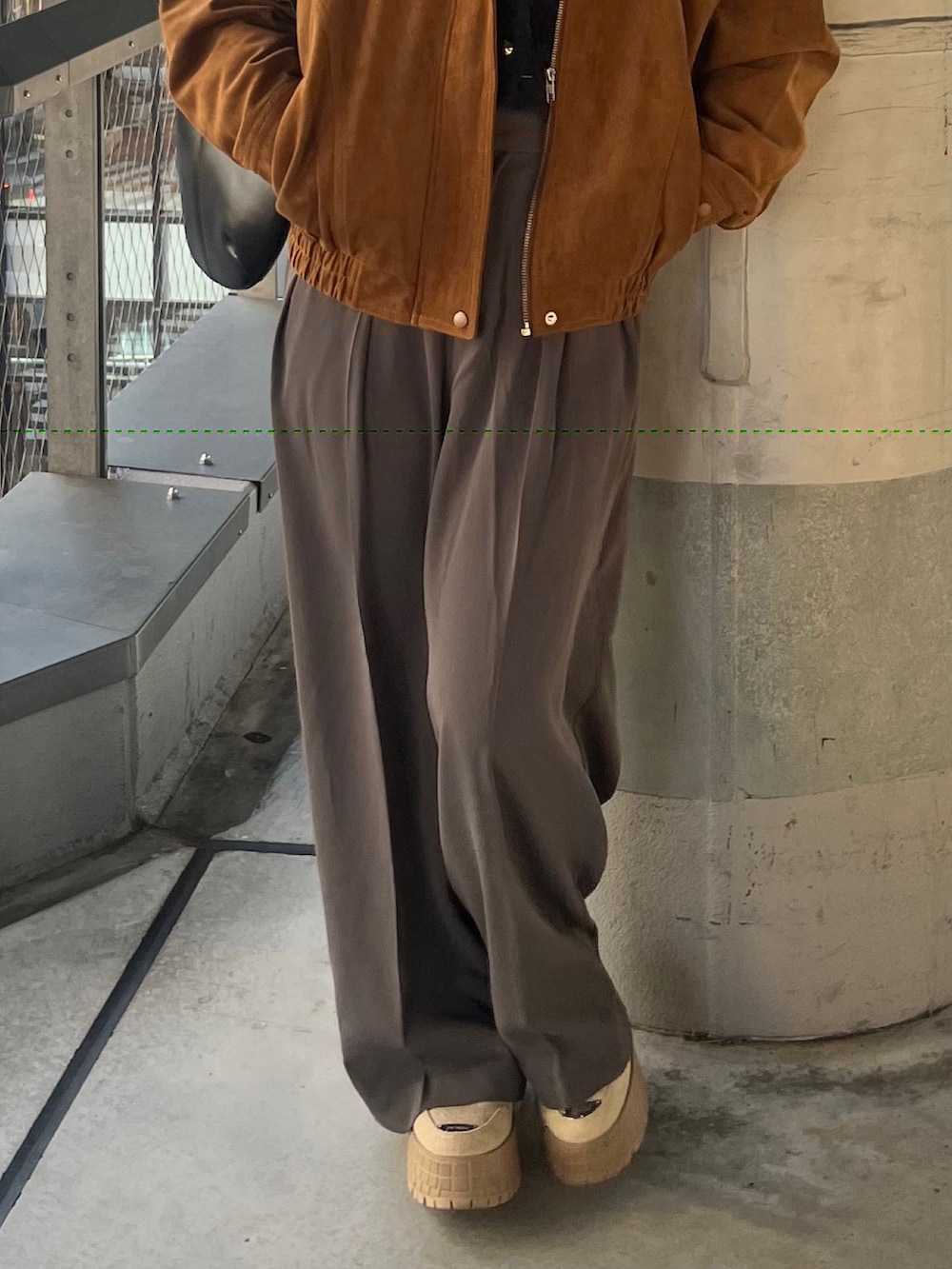 グレー系のスラックス、ブラウン系のブルゾン、ブルー系のニット/セーターを着用したレディースの秋コーディネートの3枚目の写真